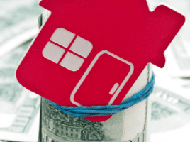 red house cutout in a jar filled with cash